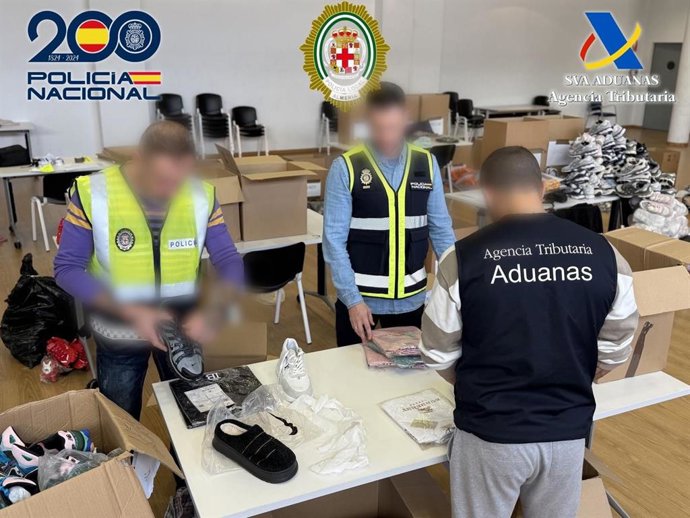 Agentes de Policía Nacional, Vigilancia Aduanera de la Agencia Tributaria y Policía Local durante la intervención de productos falsificados en el barrio de El Puche (Almería).