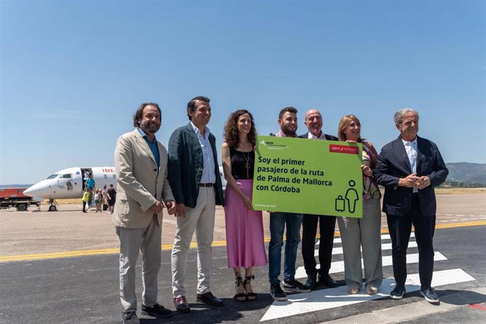 Archivo - El primer pasajero (centro) llegado a Córdoba en vuelo regular de Air Nostrum tras 16 años es recibido por las autoridades, en julio de 2024.