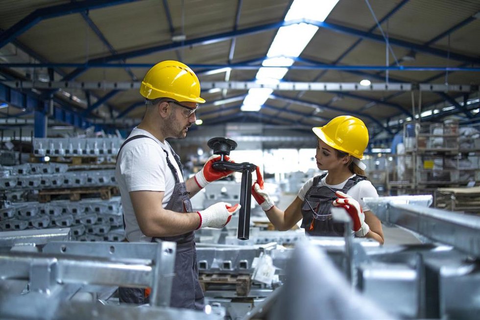 Archivo - Workers checking parts manufactured in factory.