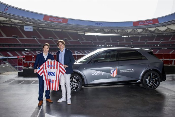 Oscar Mayo, director general de Ingresos y Operaciones del Club Atlético de Madrid, y Alberto González, director general de Cabify España,  posan con una camiseta para anunciar el patrocinio de la plataforma de mobilidad del club colchonero.