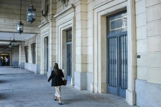 Archivo - Una mujer camina hacia la Audiencia de Sevilla en imagen de archivo.
