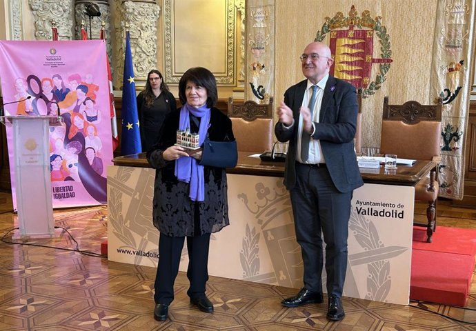El alcalde de Valladolid aplaude a la médico de Familia María del Carmen Fernández, homenajeada en el acto del Día de la Mujer en Valladolid.