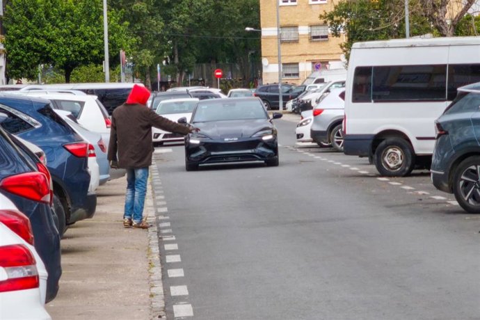 Un aparcacoches indica un lugar de estacionamiento a un conductor.