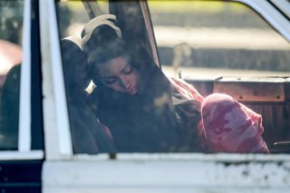 Refugiada libanesa duerme en un coche tras huir de los ataques israelíes en Beirut, Líbano