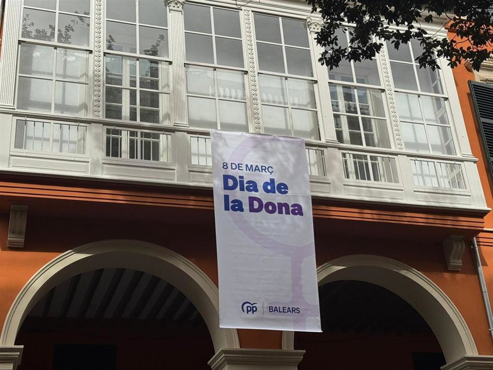 Una bandera por el 8M colgada de la sede del PP de Baleares.