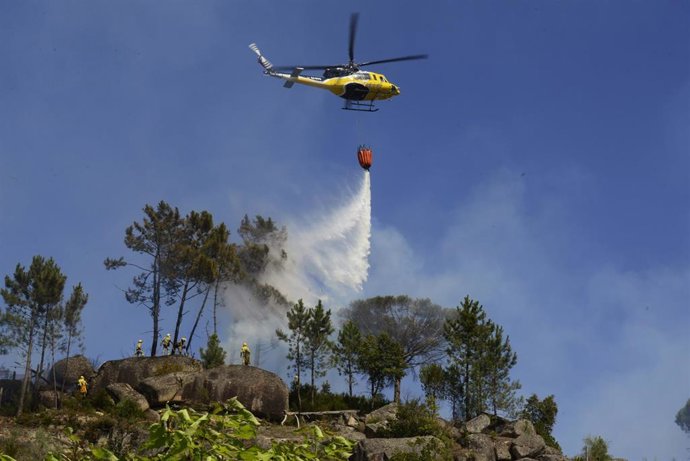 Archivo - Un helicóptero arroja agua sobre un incendio forestal, a 28 de julio de 2021, en la parroquia de Santa Mariña do Monte, Ourense, Galicia (España). Un total de seis aviones y dos helicópteros trabajan para controlar este incendio que actualmente 