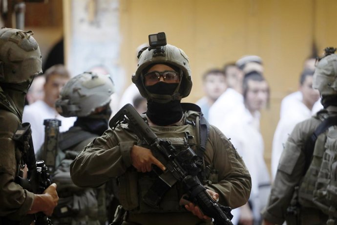 HEBRON, 7 de setembro de 2025 — Membros das forças israelenses montam guarda enquanto colonos israelenses visitam uma comunidade habitada principalmente por palestinos na cidade de Hebron, na Cisjordânia, em 6 de setembro de 2025.