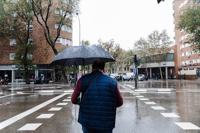 Archivo - Un hombre se protege de la lluvia con un paraguas, a 2 de noviembre de 2023, en Madrid (España). La Agencia Estatal de Meteorología (AEMET) ha activado la alerta roja en Madrid por fuertes vientos provocados por la borrasca Ciarán. En la mañana 