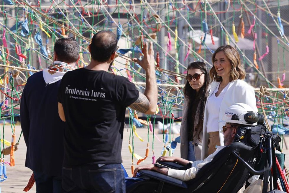 La alcaldesa de Valncia, María José Catalá, junto al activista por los derechos de las personas con ELA Jordi Sabaté visitando el montaje de la novena 'masclet' de las Fallas 2026.