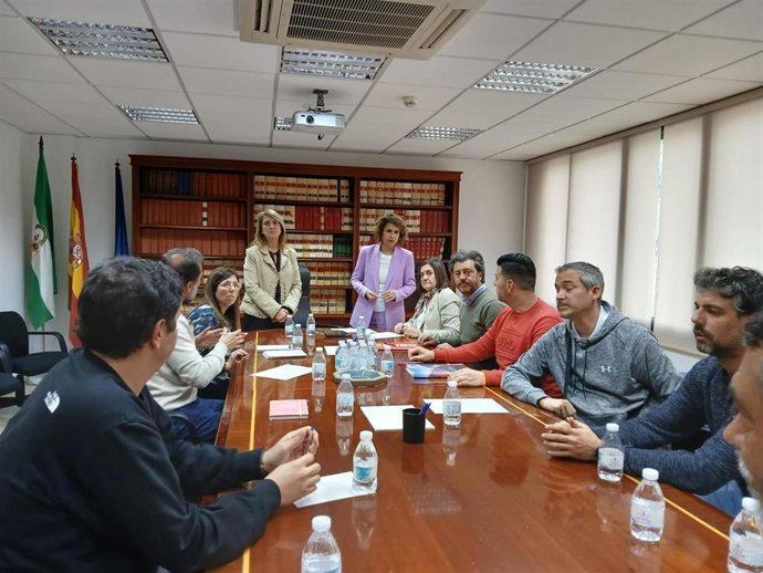 La subdelegada en Córdoba, Ana López, y María Jesús Montero (de pie, al fondo), en el encuentro con responsables de CCOO y representantes del comité de empresa de Hitachi.