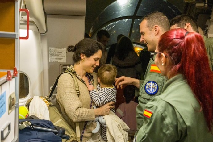 Uma mulher e seu bebê na chegada a Madri dos passageiros evacuados de Omã.