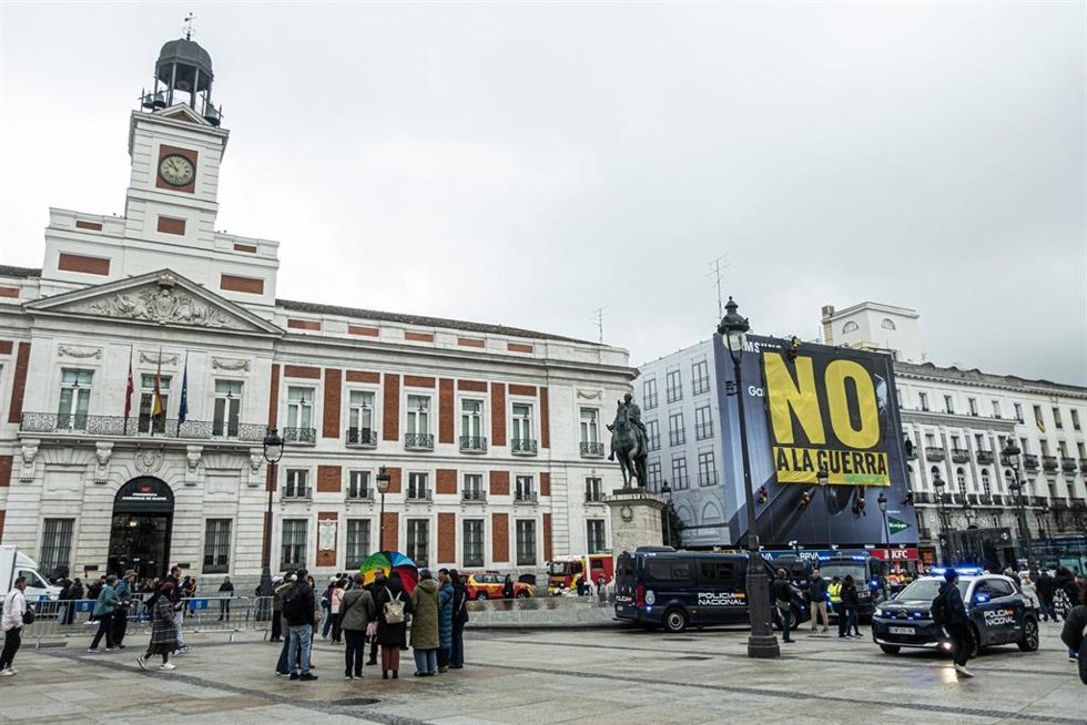 Varias personas miran la pancarta de Greenpeace con el mensaje No a la guerra, en la Puerta del Sol, a 10 de marzo de 2026, en Madrid (España). Activistas de Greenpeace han descolgado hoy una pancarta gigante con el mensaje No a la guerra en la Puer
