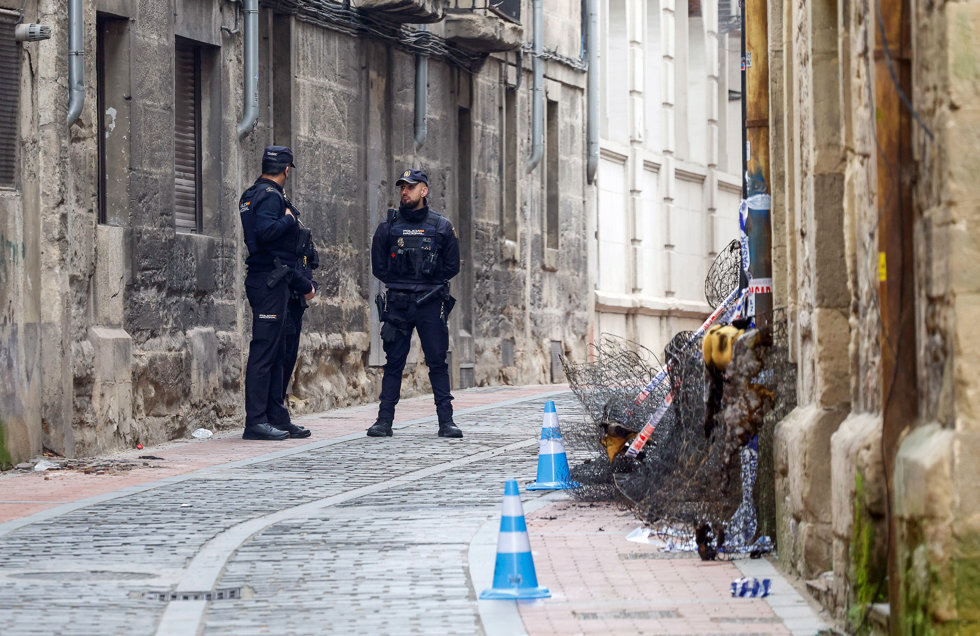 Agentes de la Policía junto a la vivienda afectada por el incendio.