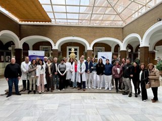 Foto de familia de la mesa redonda organizada por el Club de Lectura 'Mis ganas ganan' que involucra a usuarios y pacientes acerca de tatuajes reparadores sobre lesiones en la piel de pacientes del Hospital Universitario Virgen del Rocío de Sevilla.