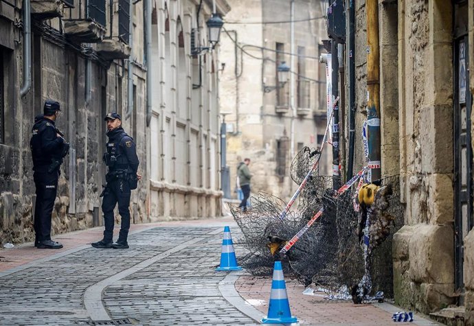 Dos agentes custodian la entrada del edificio en el que se ha producido el incendio, a 11 de marzo de 2026, en Miranda de Ebro, Burgos, Castilla y León (España).