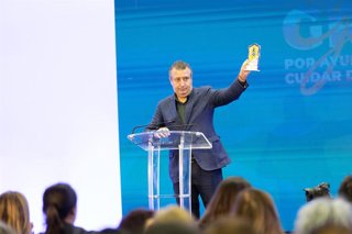 El alcalde de La Rinconada, Javier Fernández, con la distinción otorgada al municipio de 'Excelencia en inversión social', en un acto público con vecinos y colectivos sociales.