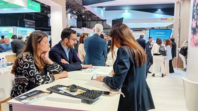 Una pareja recibe información de la oferta de Aedas Homes en el SIMA.