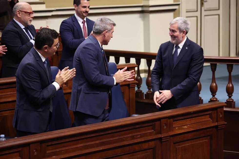 El consejero de Obras Públicas del Gobierno de Canarias, Pablo Rodríguez y el vicepresidente Manuel Domínguez, aplauden al presidente, Fernando Clavijo, en el 'Debate sobre el Estado de la Nacionalidad Canaria'