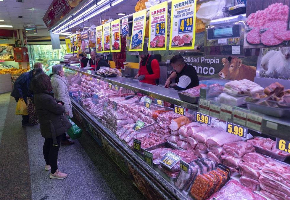 Archivo - Varias personas compran en una carnicería  en un mercado