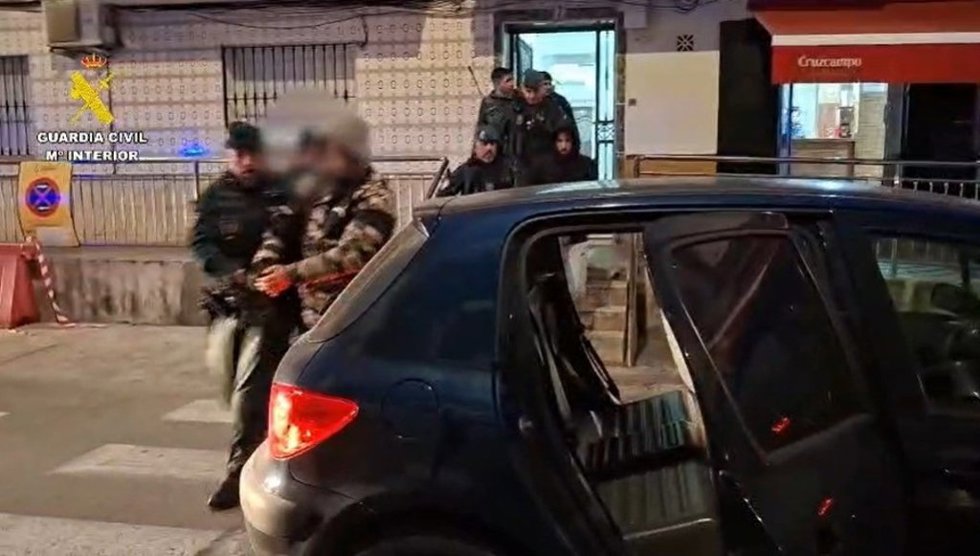 Un agente de la Guardia Civil con uno de los detenidos por el vuelco de un cargamento de droga en la provincia de Cádiz.