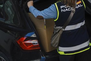 Una agente de la Policía Nacional este viernes cargando una caja en un vehículo, en el marco de los registros en instalaciones de Facpyme tras la detención de Carlos Baño