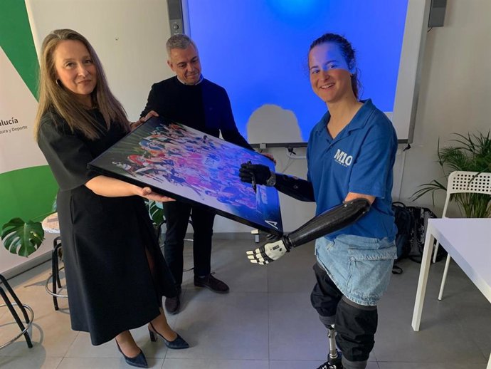 Sarah Almagro firma un póster durante su participación en una sesión del programa Mentor 10 celebrada en el CIMI 'El Molino', en Almería.