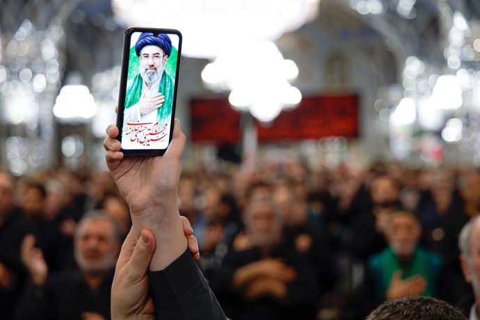 Un ciudadano sostiene imágenes del nuevo líder supremo de Irán, el ayatolá Mojtaba Jamenei