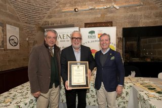 El humorista Leo Harlem (centro) recibe el reconocimiento de la DO Baena.