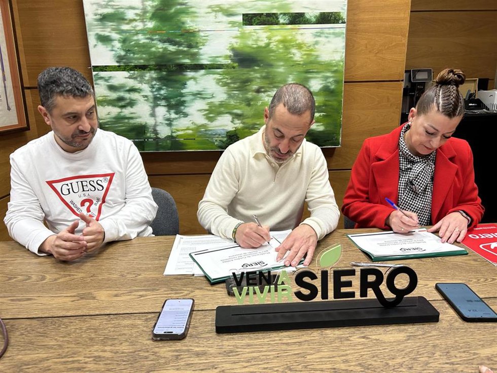 El alcalde de Siero, Ángel GArcía, y la concejala de IU, Teresa Álvarez, firman el acuerdo para aplicar el remanente de tesorería a inversiones.