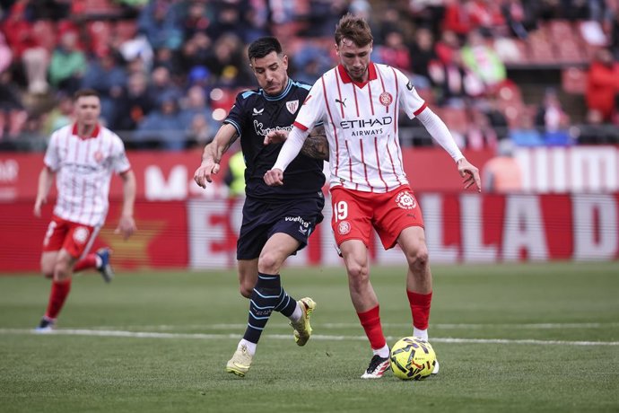 Vladyslav Vanat, do Girona FC, e Yuri Berchiche, do Athletic Club, em ação durante a partida de futebol da LaLiga EA Sports, disputada entre o Girona FC e o Athletic Club no estádio Montilivi, em 14 de março de 2026, em Girona, Espanha.