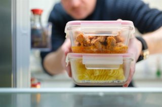 Archivo - Hombre guardando las sobras de la comida en el frigorífico.