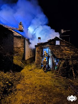 Bomberos trabajan en la extinción del incendio de una vivienda en San Tirso de Abres.