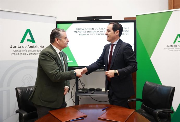 El consejero andaluz de Sanidad, Presidencia y Emergencias, Antonio Sanz, y el consejero de Justicia, Administración Local y Función Pública, José Antonio Nieto, firman un acuerdo.