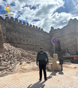 Un agente de la Guardia Civil inspecciona la zona del derrumbe de la torre albarrana del castillo de Escalona.