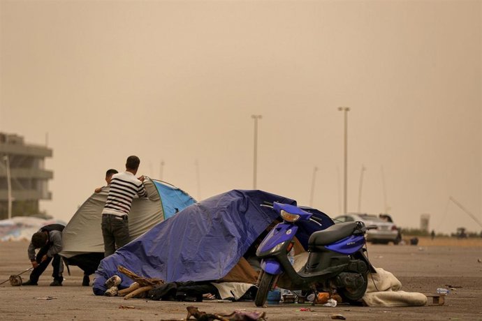 Libaneses desplazados protegen su tienda de campaña de una tormenta de arena en Beirut