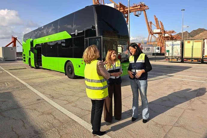 La consejera delegada de Titsa, Victoria Padilla, la presidenta del Cabildo de Tenerife, Rosa Dávila, y la consejera de Movilidad, Eulalia García, junto a una guagua de dos pisos a su llegada al puerto de Santa Cruz de Tenerife