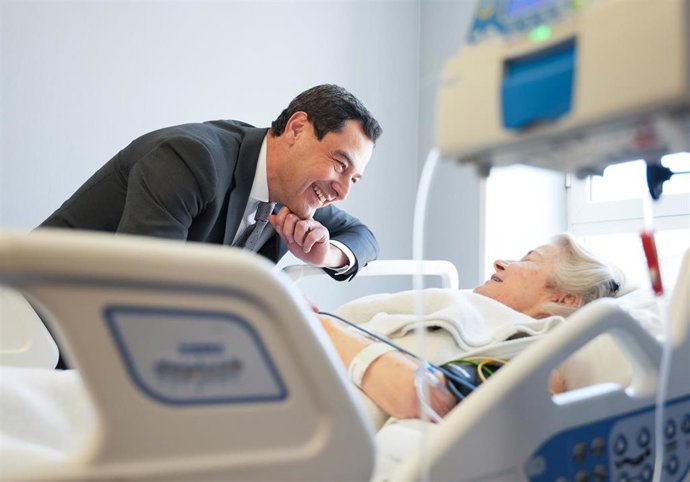 El presidente de la Junta, Juanma Moreno, con una paciente ingresada en el Hospital Universitario Virgen del Rocío de Sevilla.