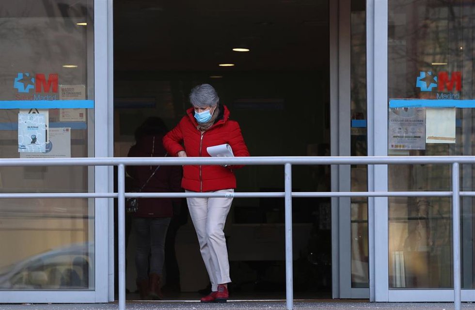 Archivo - Una mujer con una mascarilla a su salida de un centro de salud.