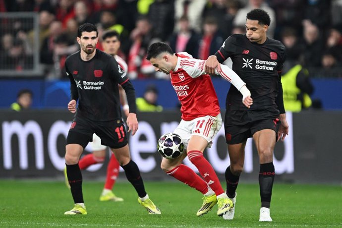 11 March 2026, North Rhine-Westphalia, Leverkusen: Bayer Leverkusen's Jarell Quansah (right) and Arsenal's Gabriel Martinelli fight for the ball, with Bayer Leverkusen's Martin Terrier on the left, during the UEFA Champions League soccer match between Bay