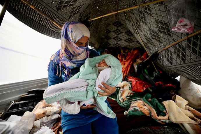 SIDON, 16 de março de 2026 — Uma mulher deslocada segurando seu bebê é vista dentro de uma barraca em Sidon, no Líbano, em 15 de março de 2026. O número de mortos pelos ataques israelenses em curso contra o Líbano subiu para 850 desde 2 de março, informou