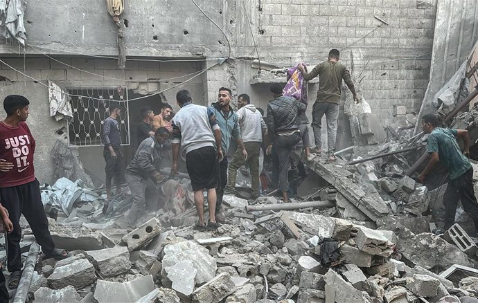 Archivo - Varias personas acuden a ayudar al lugar de un bombardeo israelí en Nuseirat, en la Franja de Gaza