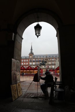 Archivo - Un pintor pinta un cuadro en uno de los accesos a la Plaza Mayor