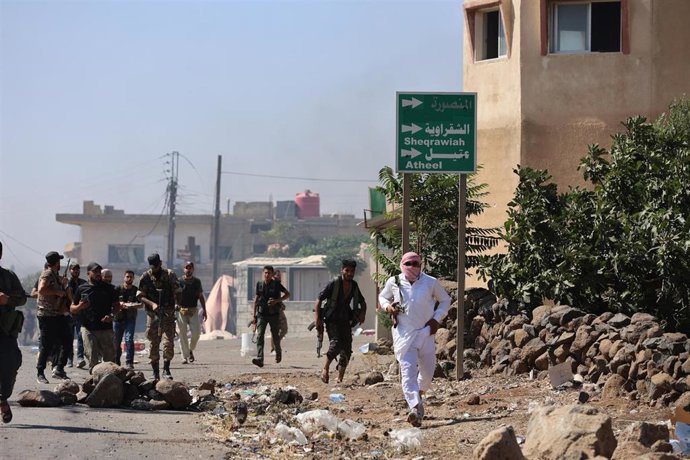 Archivo - Combatientes beduinos avanzan por la ciudad de Wolgha, en la provincia siria  de Sueida, en el sur del país