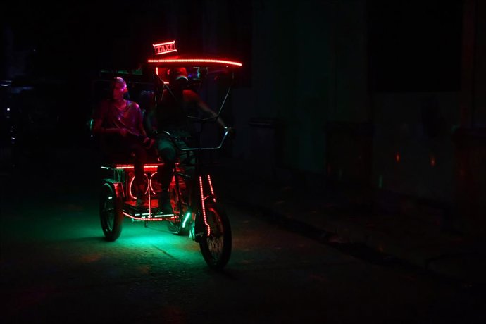 HAVANA, 17 de março de 2026  -- Pessoas se deslocam de triciclo durante um apagão nacional em Havana, Cuba, em 16 de março de 2026. A rede elétrica nacional de Cuba sofreu um apagão total na segunda-feira, e o processo de restabelecimento da energia elétr