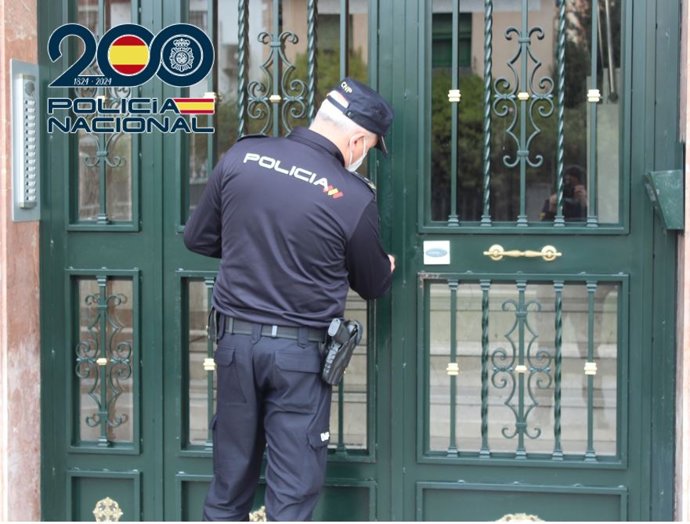 Un agente de la Policía Nacional inspecciona un portal.