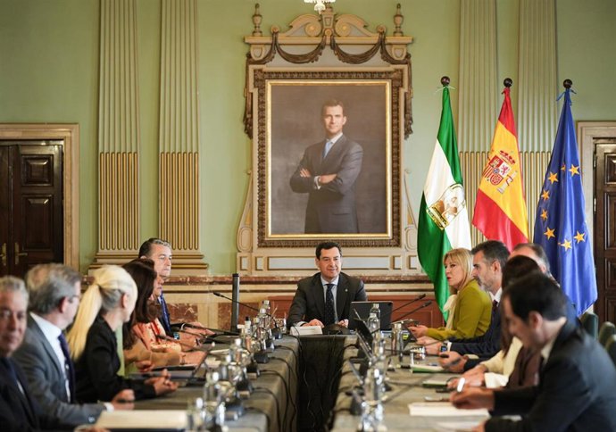 El presidente de la Junta de Andalucía, Juanma Moreno (c), preside en Huelva la reunión ordinaria del Consejo de Gobierno. 