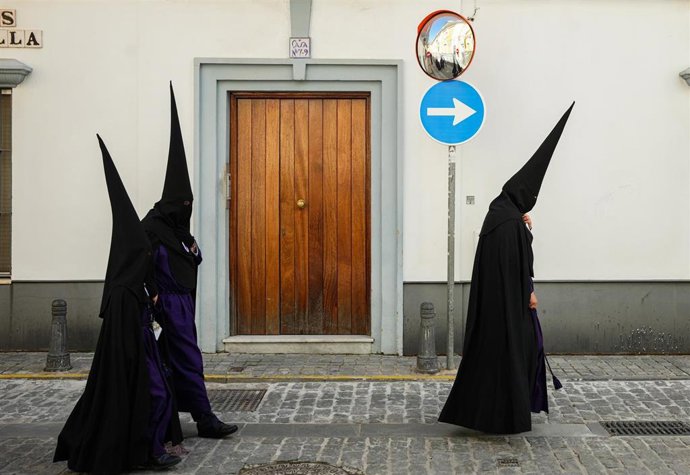 Archivo - Varios nazarenos se dirigen a la iglesia de San Bernardo para realizar su estación de penitencia el Miercóles Santo de la Semana Santa 2025.