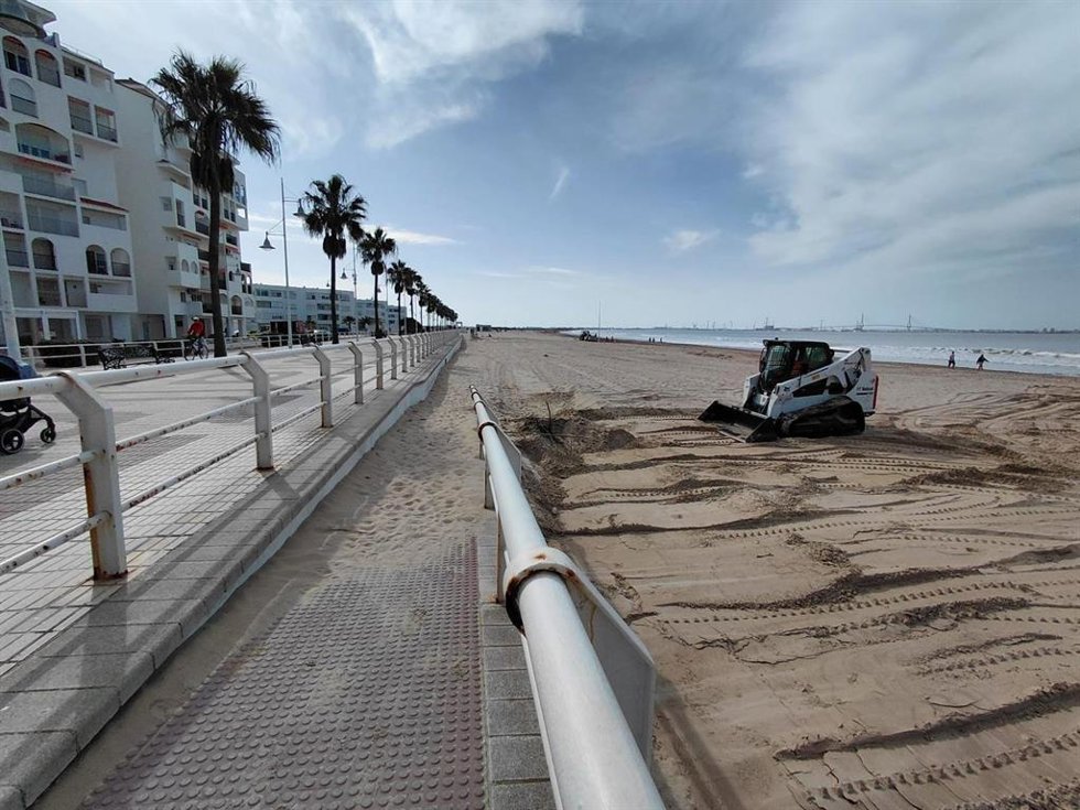 Operarios trabajando en el adecentamiento de la playa de Valdelagrana en El Puerto de Santa María (Cádiz)