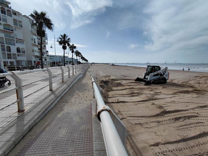 Operarios trabajando en el adecentamiento de la playa de Valdelagrana en El Puerto de Santa María (Cádiz)