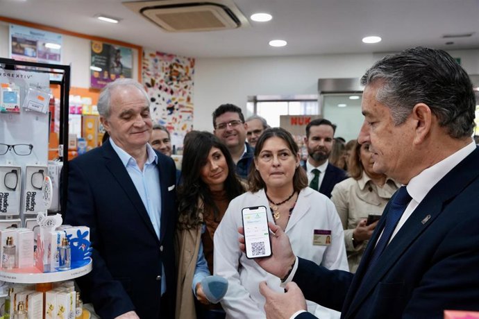 El consejero de Sanidad, Presidencia y Emergencias de la Junta de Andalucía, Antonio Sanz, en una farmacia sevillana presentando la nueva tarjeta virtual.